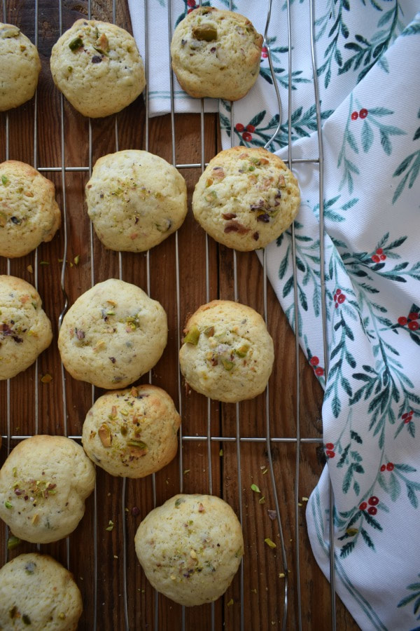 mascarpone pistachio cookies on a cooling rack with a christmas tea towel