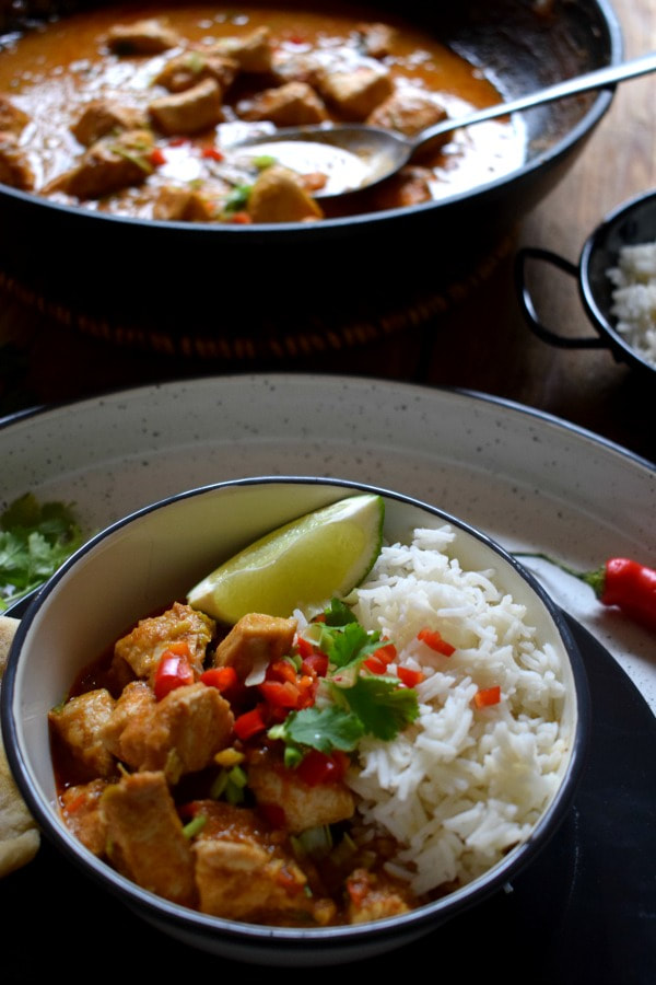 Red Thai Chicken Curry in a bowl with rice and a lime wedge