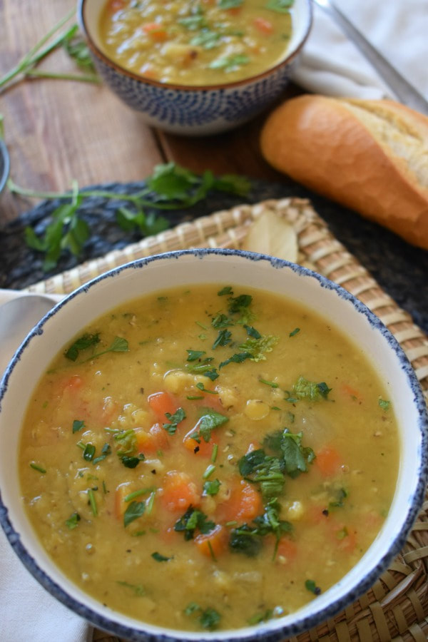 split pea and carrot soup in a bowl with soup in the background