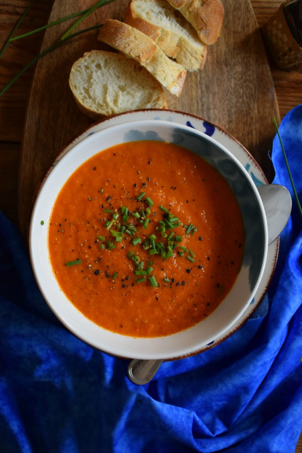 OVERHEAD view of the Roasted Tomato Soup with bread and a blue napkin