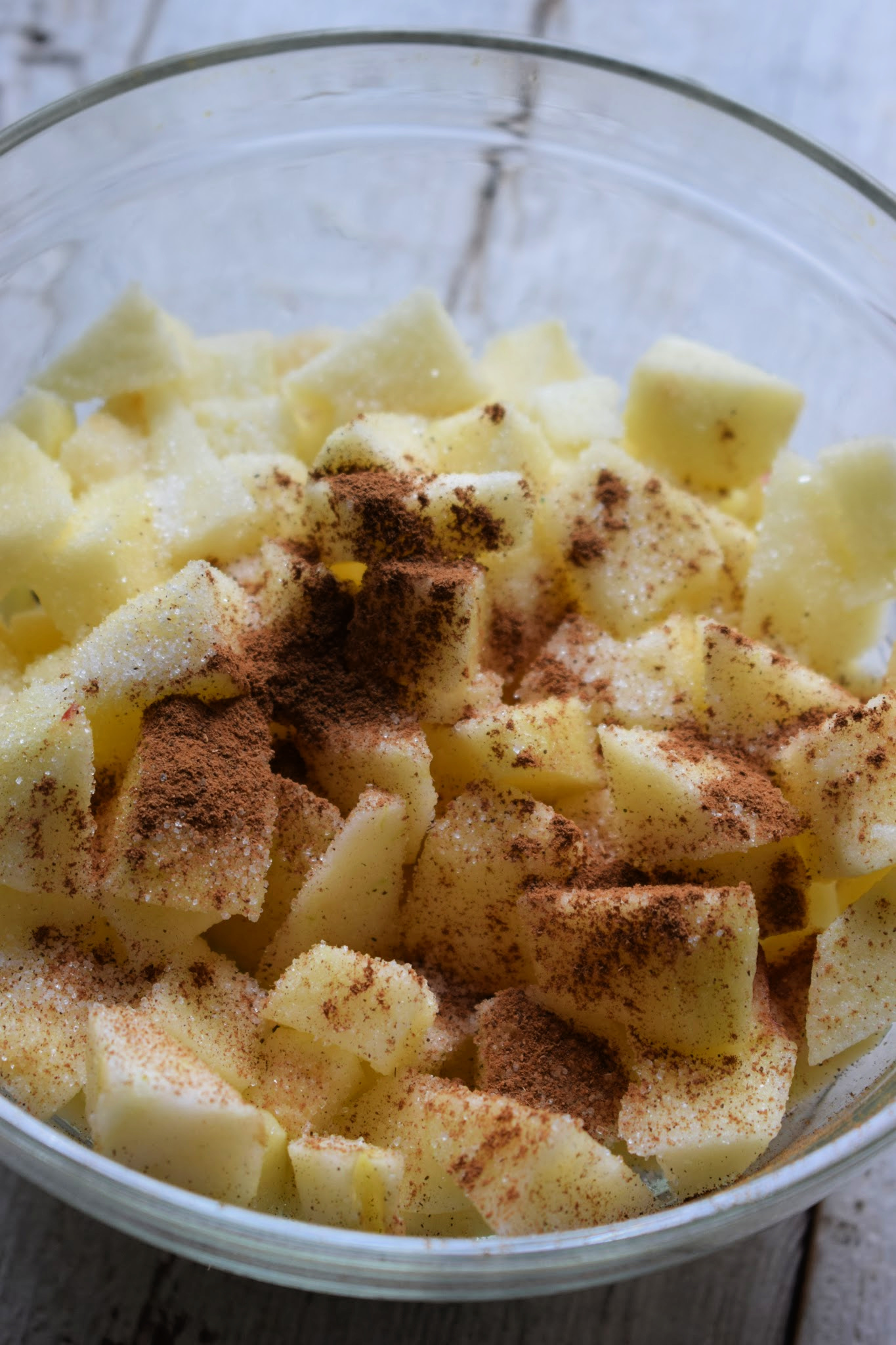 Apples, cinnamon and sugar in a bowl to make mini apple crumbles.