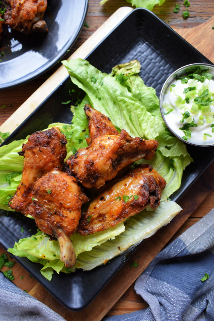 Crispy Chicken Wings on a plate with lettuce and a dipping sauce