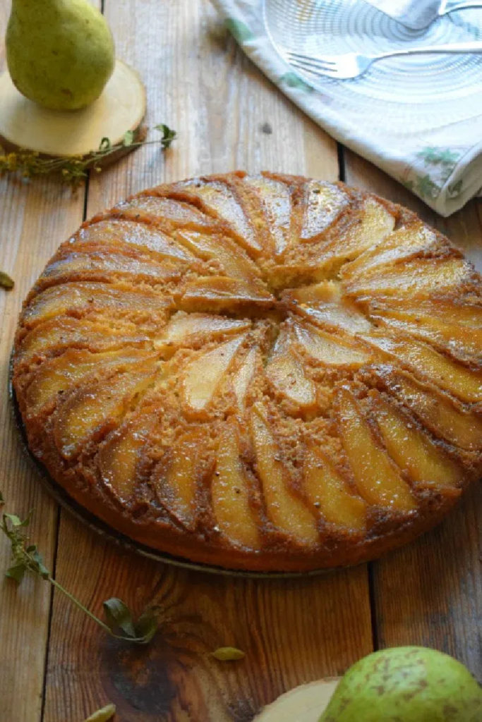 Pear & Cardamom Cake on a wooden board with pears