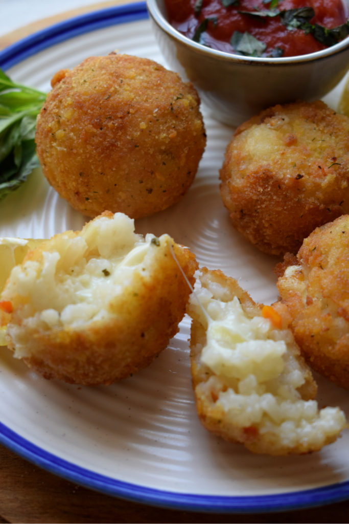 close up of arancini with a dipping sauce