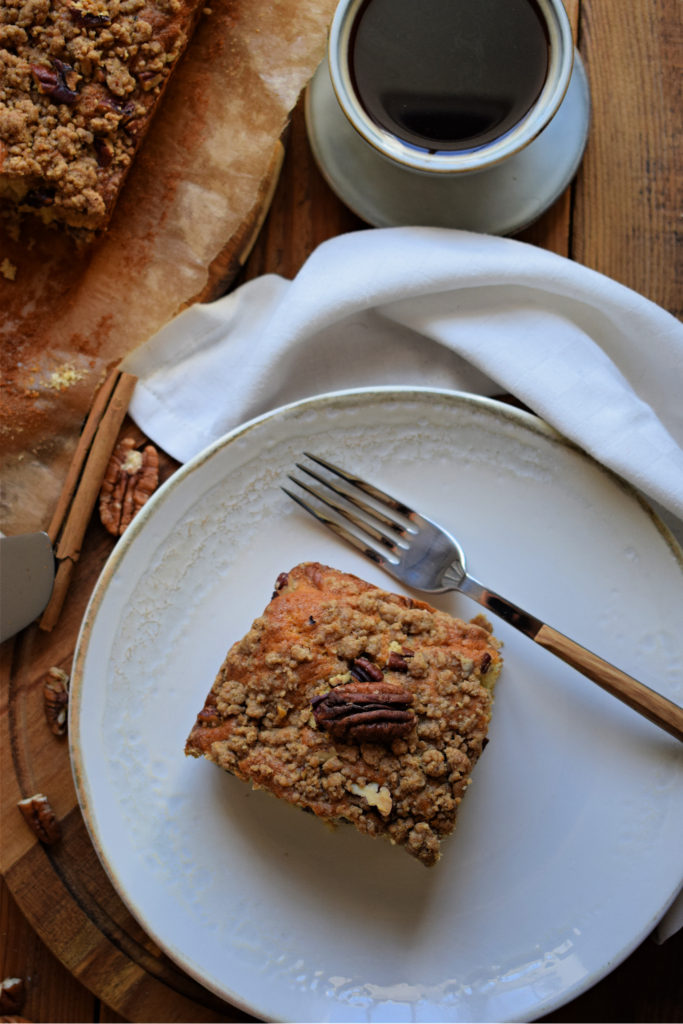 pecan cake on  a white plate with a napkin and fork