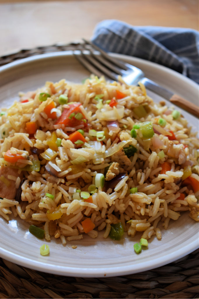 Turkey fried rice on a beige plate with a fork