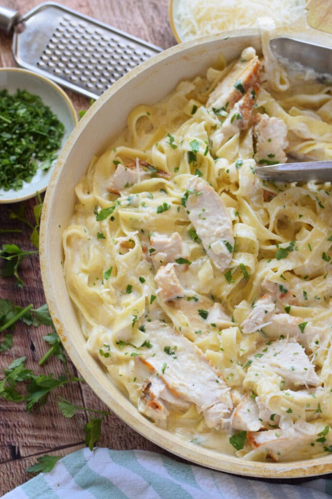 Creamy chicken alfredo in a white skillet.