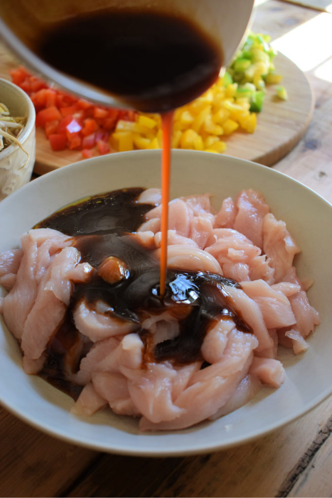 pouring a marinade over chicken