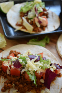 Ground pork tacos on a table.