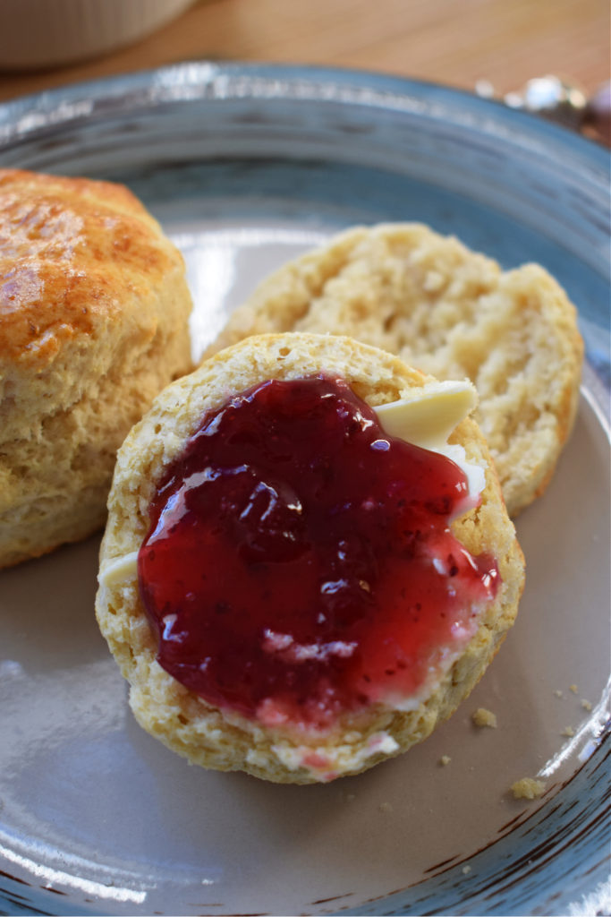 close of of a big fluffy scone with jam