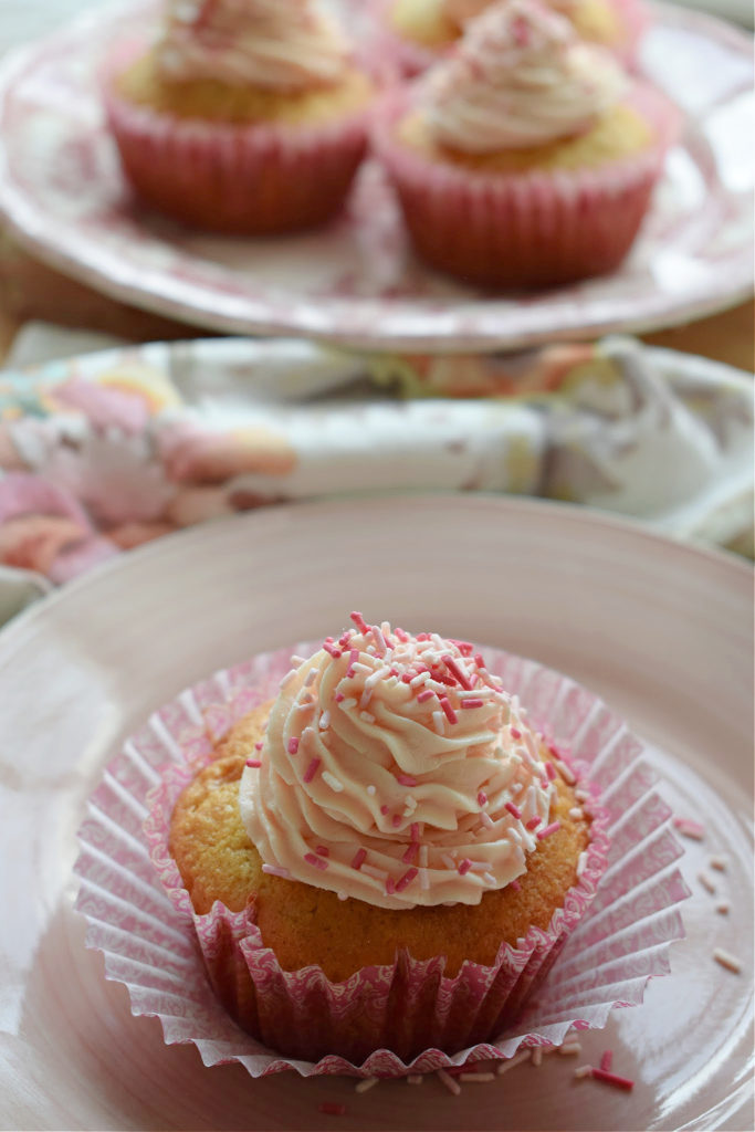 Fresh Strawberry Cupcakes with Buttercream frosting on a plate and some in the background
