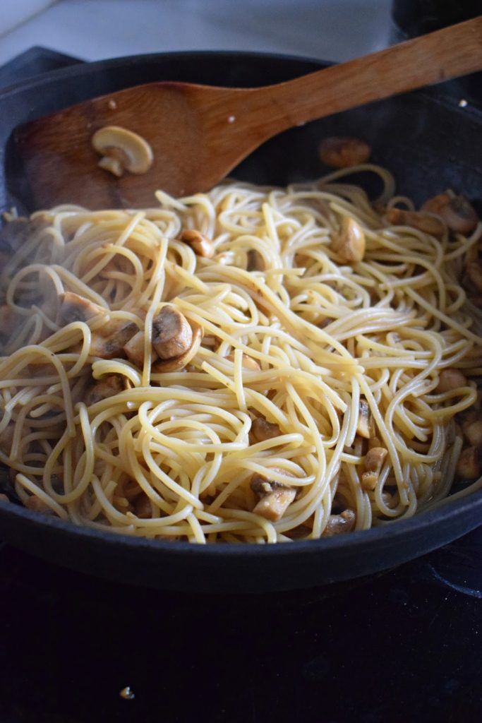 spaghetti and mushrooms in a skillet