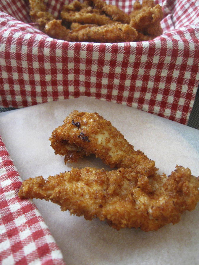Crispy Fried Chicken on a plate with a basket in the background