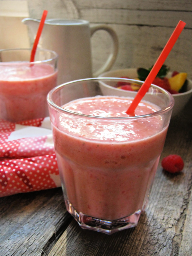 close upf of the mango and berry smoothie in a glass