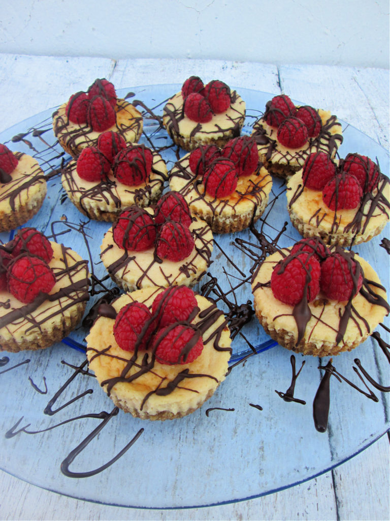 MINI CHOCOLATE TOPPED RASPBERRY CHEESECAKE ON ASERVING DISH