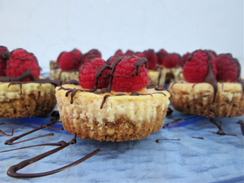 CLOSE UP VIEW OF THE MINI CHOCOLATE TOPPED RASPBERRY CHEESECAKE