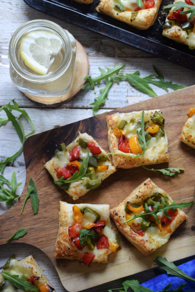 over head view of the Roasted Bell Pepper Puff Pastry Bites with a glass of water
