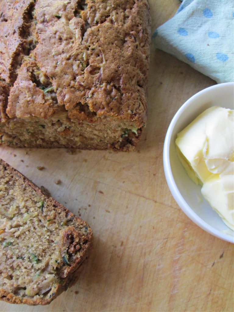 zucchini loaf bread on a cutting board with butter
