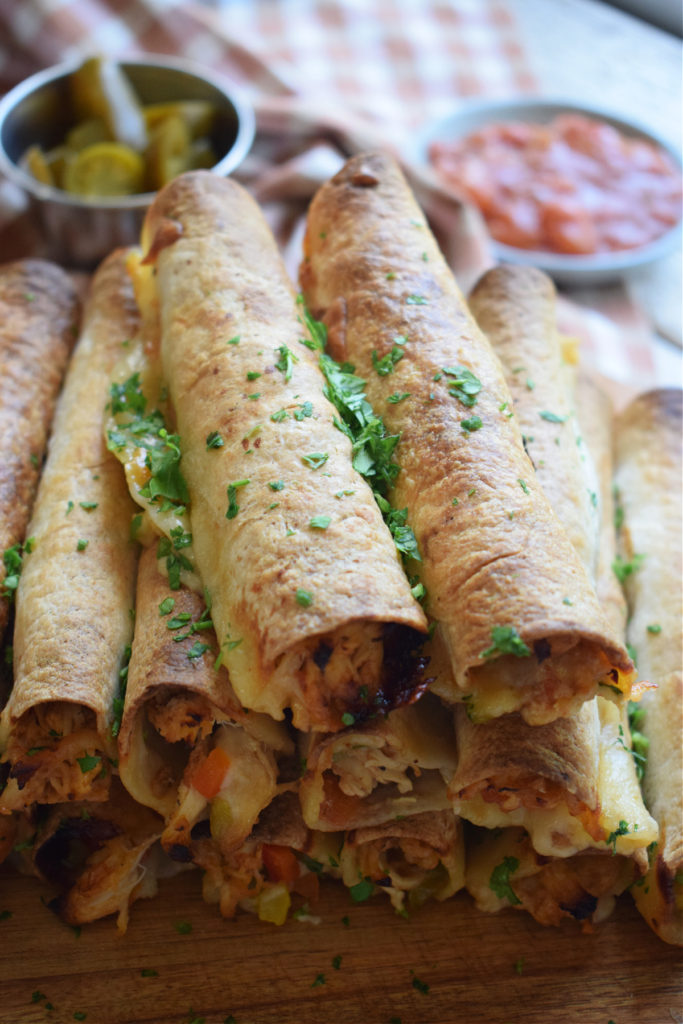 close up of a stack of slow cooker chicken taquitos