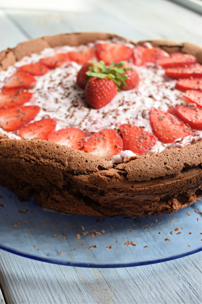 A strawberry Filled chocollate torte on a glass plate