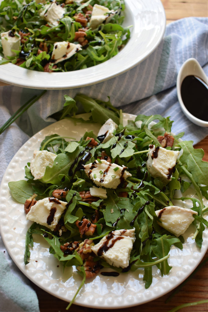 goat cheese and pecan salad on a white plate