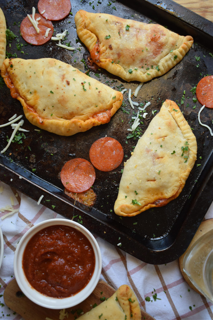 homemade pepperoni calzones on a baking tray