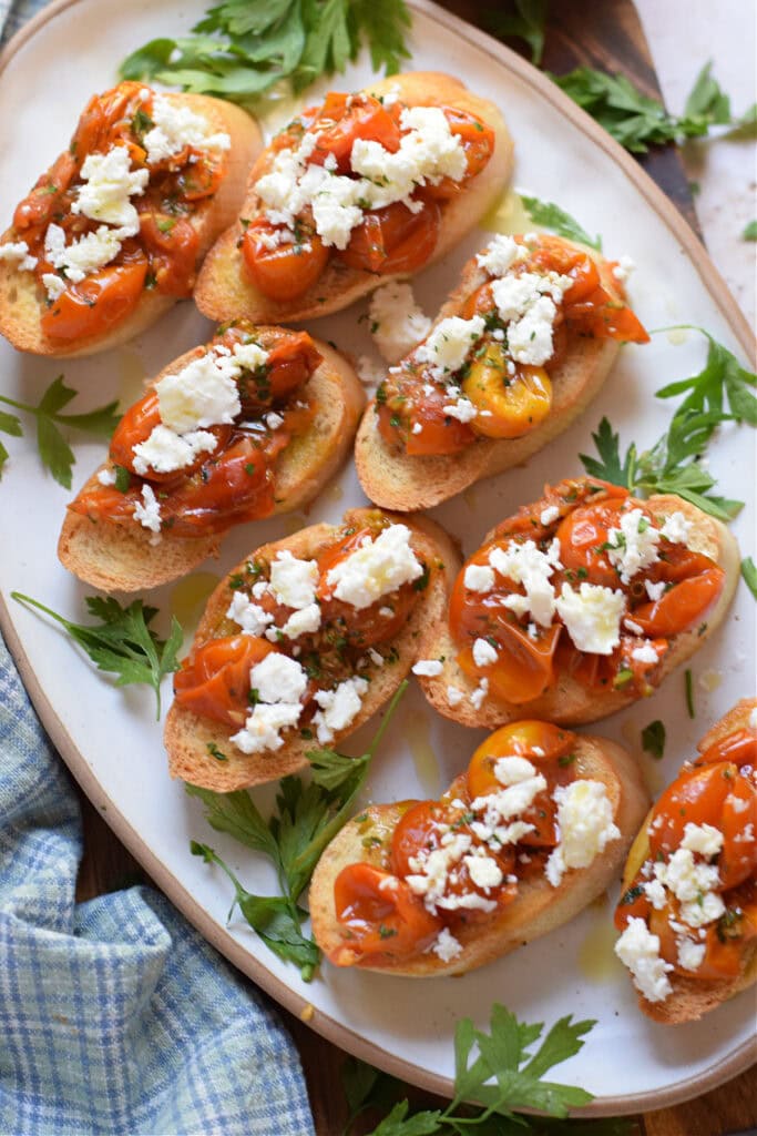 Tomato and feta bruschetta on a white plate.