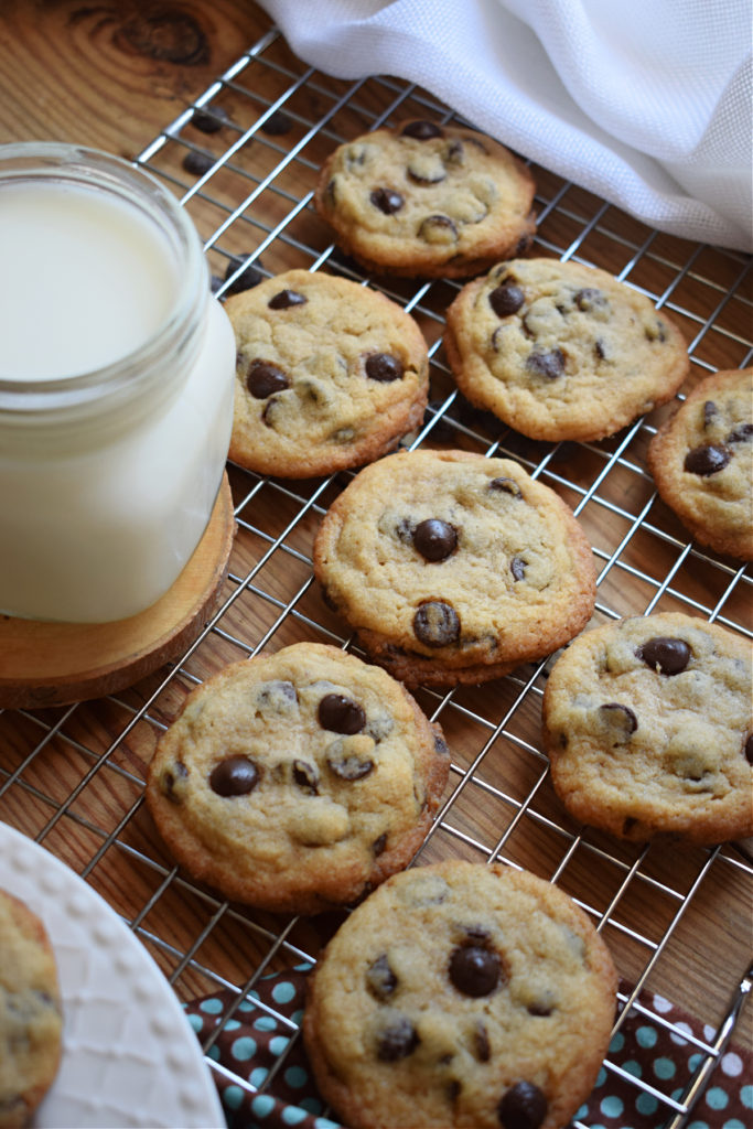 chocolate chip cookies on a cooling rack with a glass of milk