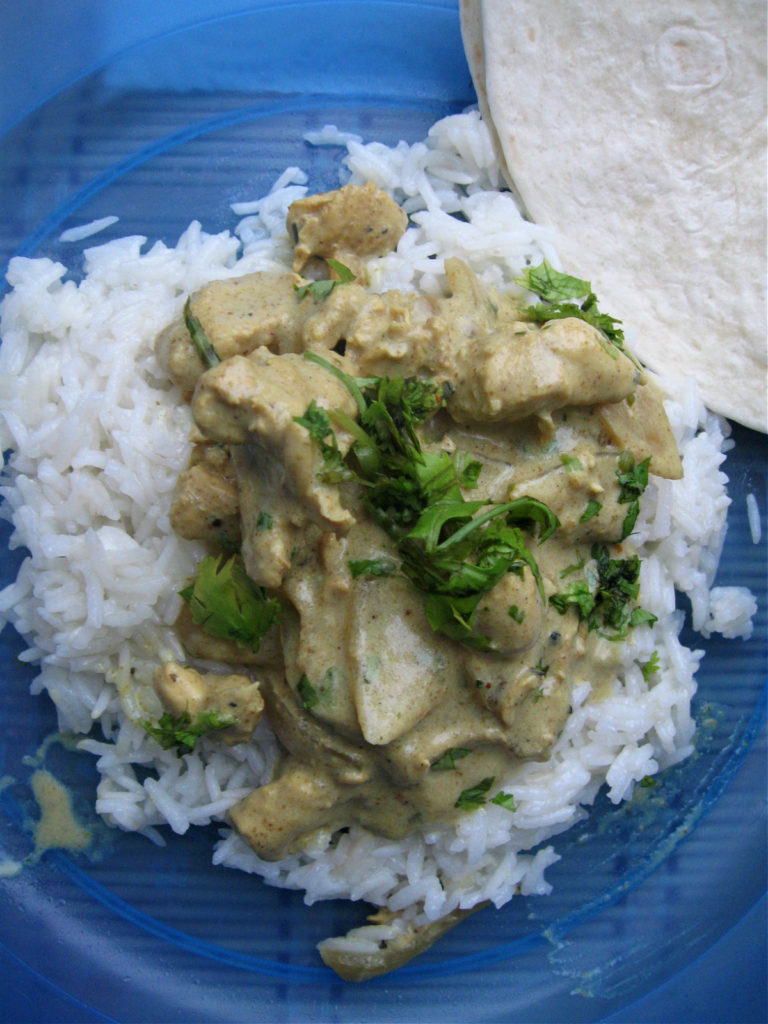 chicken masala and rice on a blue plate