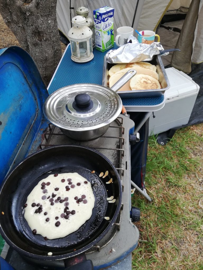 chocolate chip pancakes cooking on a camping stove