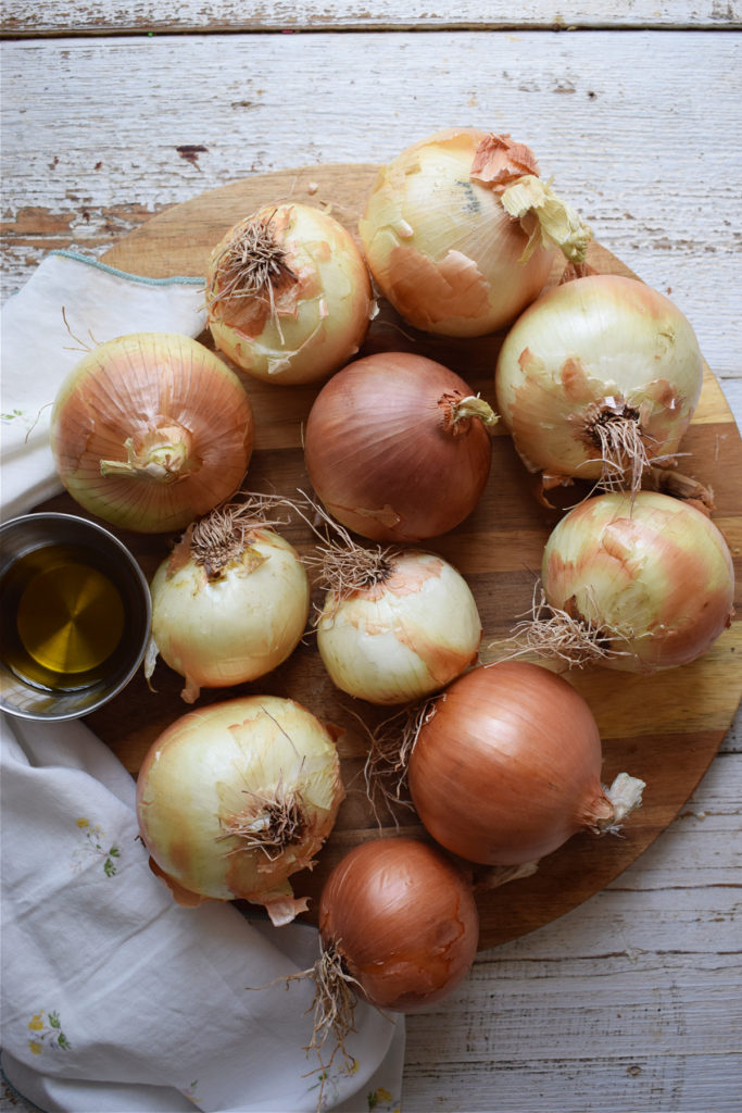 onions on a wooden board to make caramelized onions