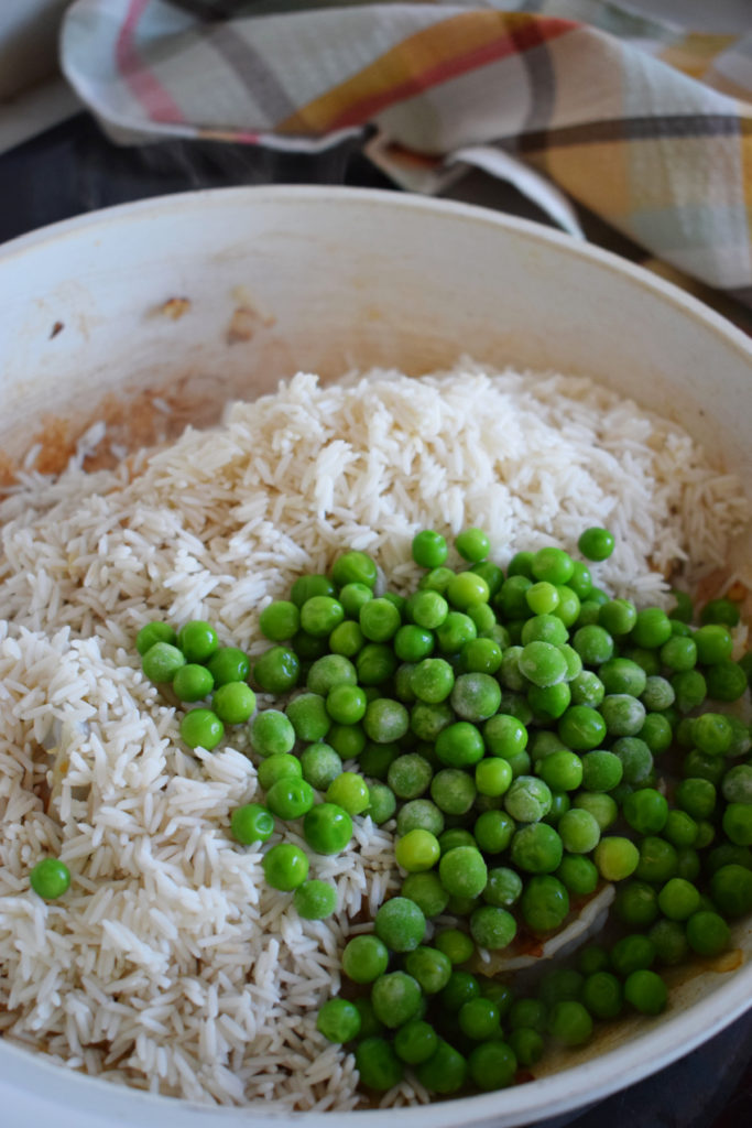 adding peas and rice to the pan to make the easy teriyaki shrimp and rice
