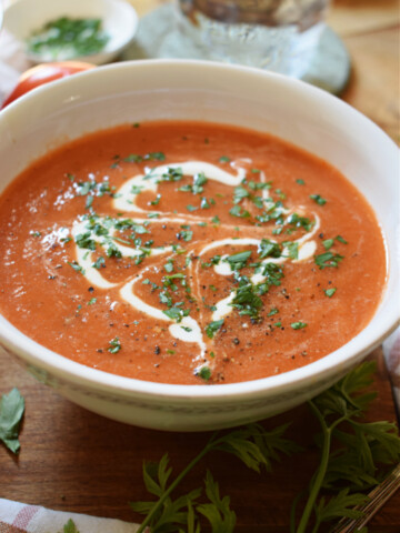 close up of a bowl of tomato soup with fresh cream