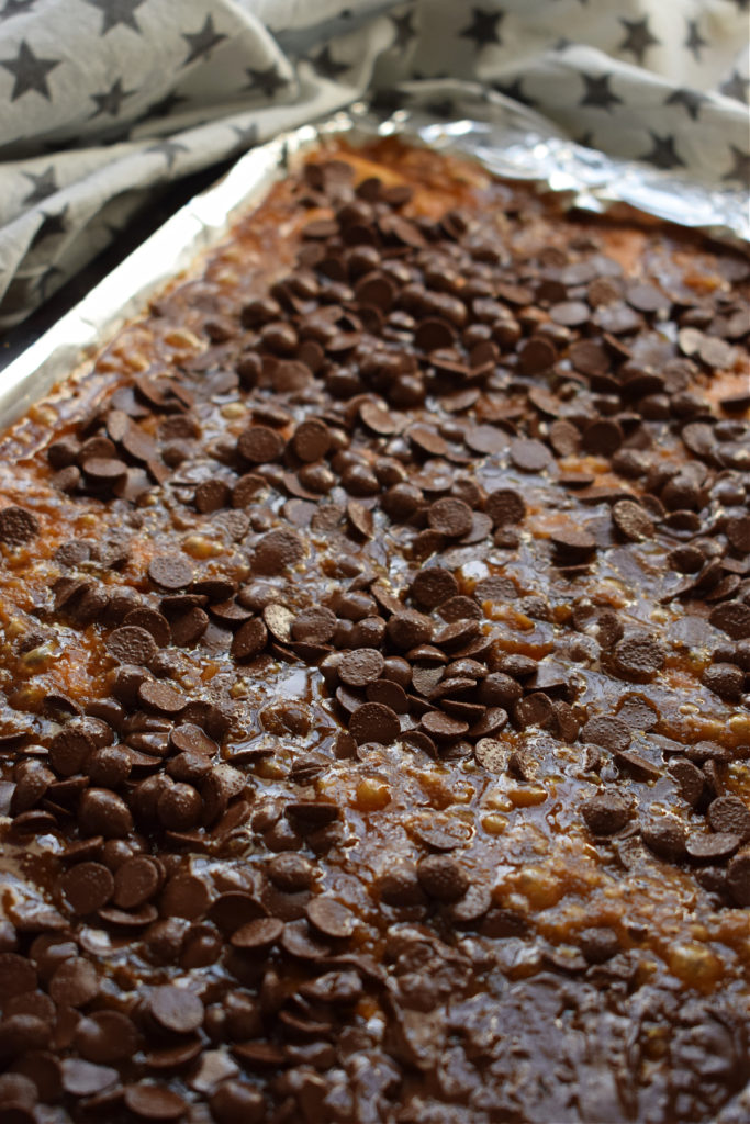 Chocolate chips on top of a caramel layer.