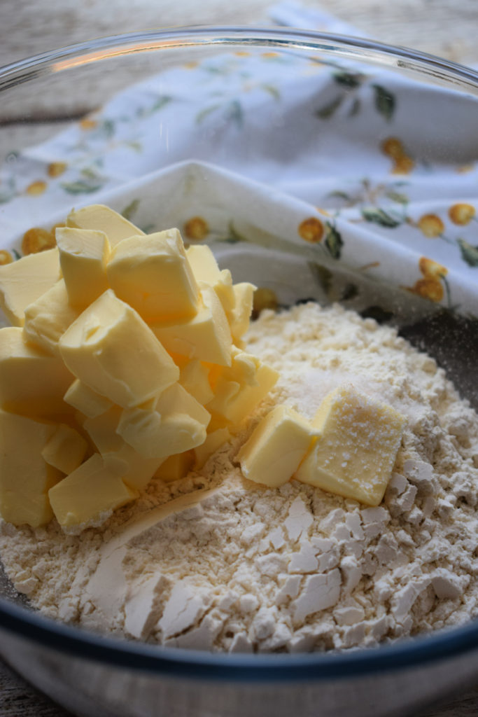adding butter to flour to make pie pastry