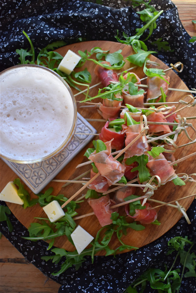 over head view of the Spanish Ham and Cured Cheese Bites with a glass of beer