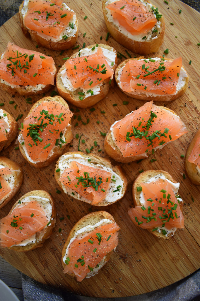 smoked salmon and cream cheese canapes on a wooden board