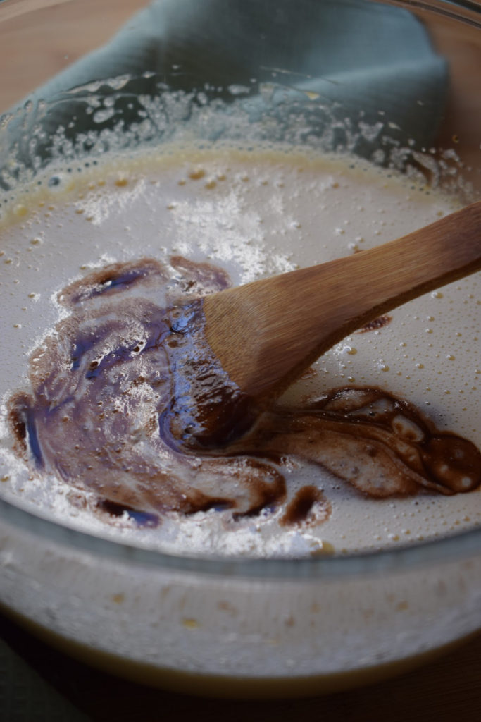adding chocolate to batter to make brownies
