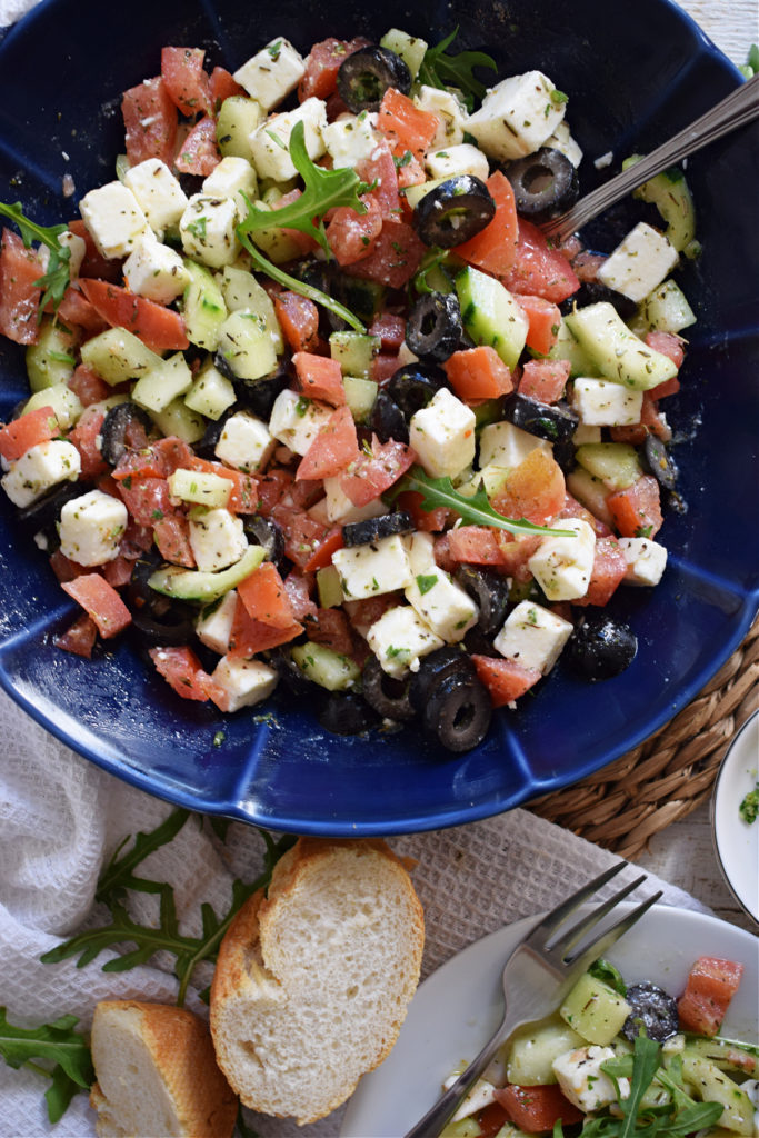 chopped vegetable and feta salad in a blue bowl