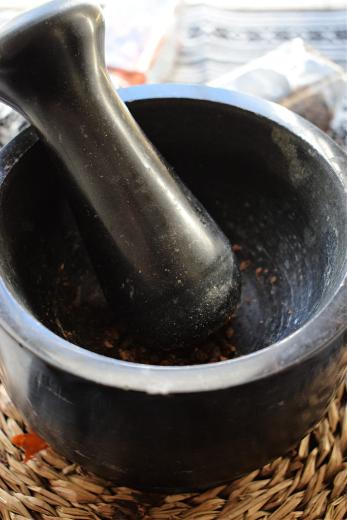 crushing spices with a mortar and pestel