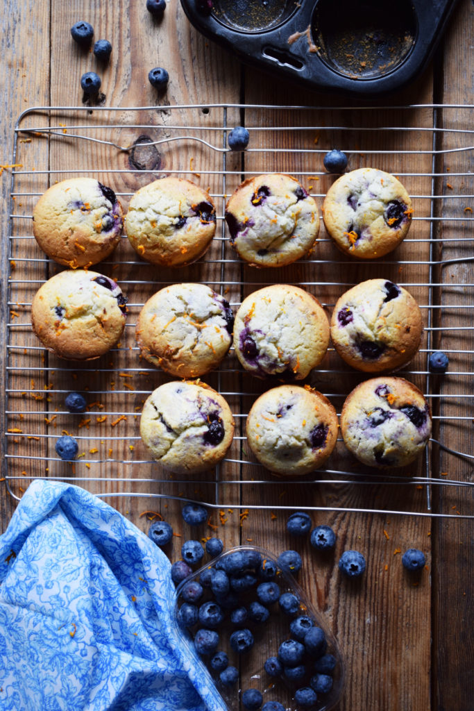 orange and blueberry muffins on a cooling rack.