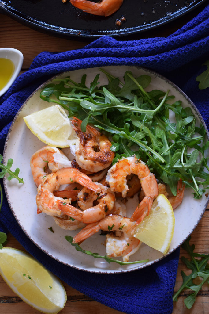 lemon shrimp on a plate with a salad.