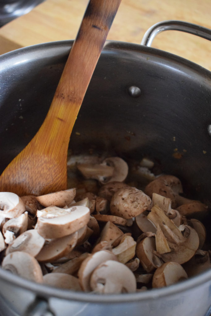 Adding mushrooms to make risotto.