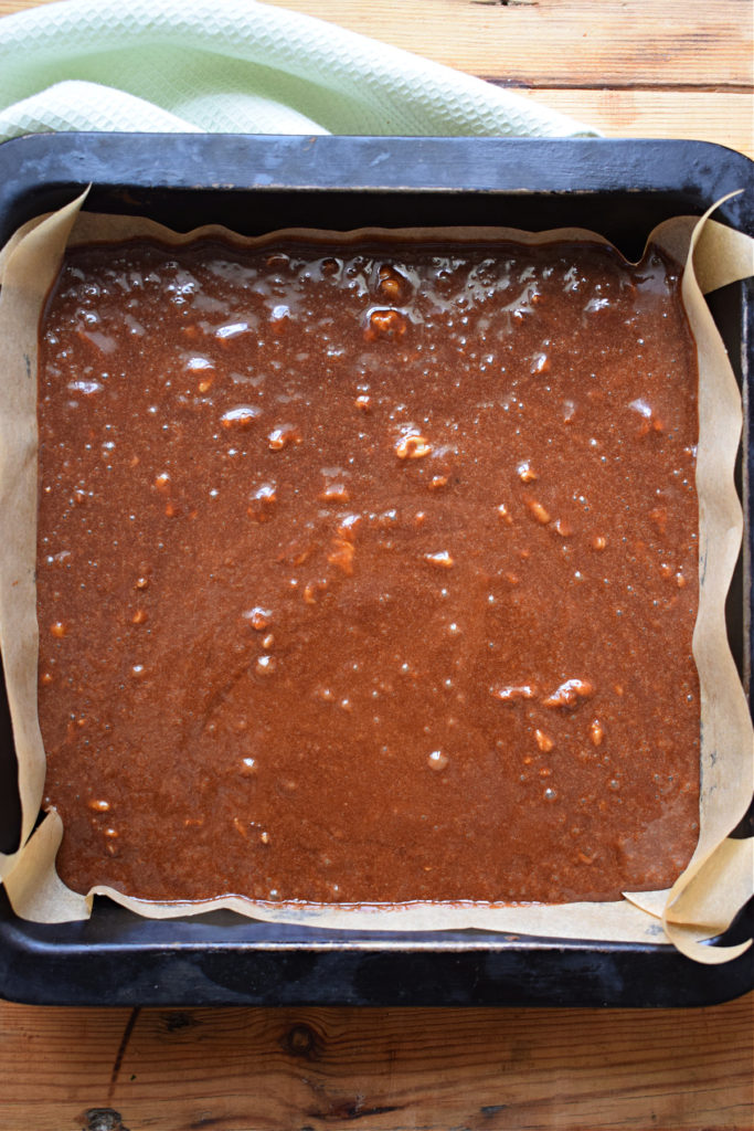 Brownie batter poured into a prepared pan.