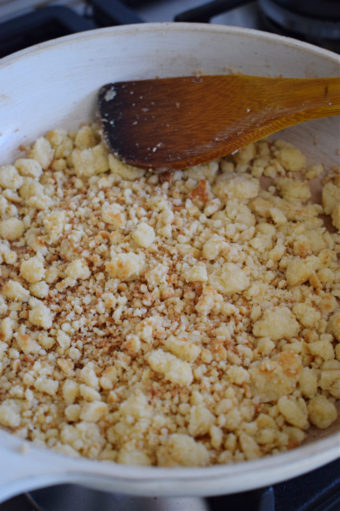 cooking crumble topping in a skillet.