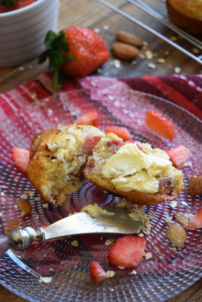 strawberry muffin with butter on a plate.