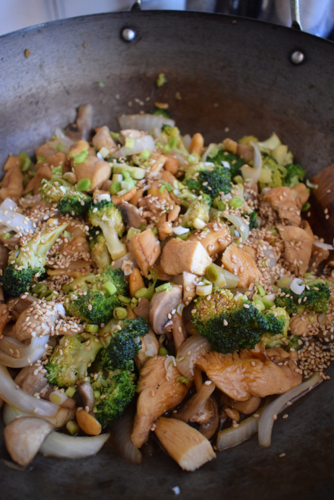 Chicken and broccoli stir fry in a wok.