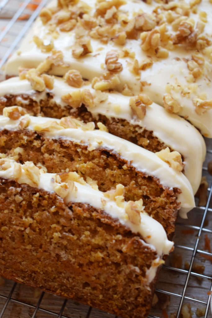 close up of sliced carrot cake loaf with cream cheese frosting.