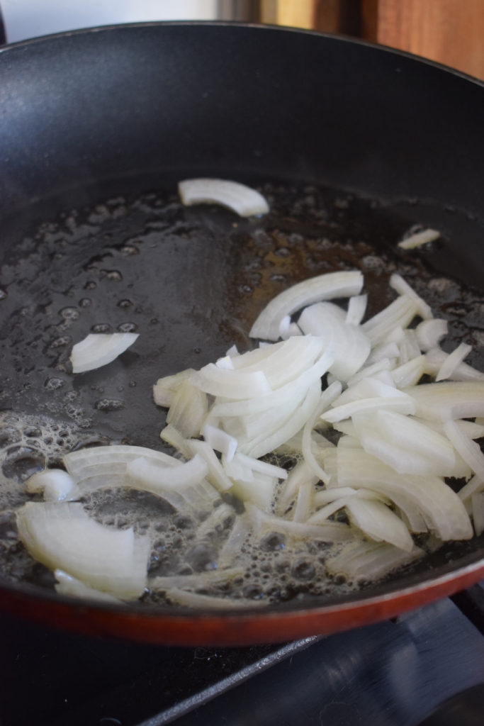 Cooking onions to make pasta primavera.
