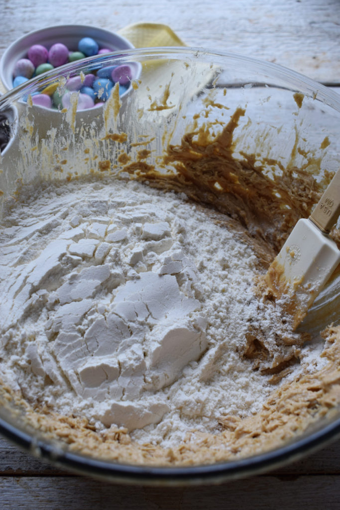 Adding flour to cookie dough.